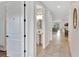 Bright hallway featuring neutral tile floors, white walls, with views of a powder room and the living space at 7643 Wilmington Loop, Kissimmee, FL 34747