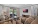 Inviting living room featuring contemporary furnishings, a flat-screen TV, and sliding doors leading to the pool area at 7643 Wilmington Loop, Kissimmee, FL 34747