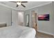 Bedroom featuring a ceiling fan, TV, and multiple doorways including one to an attached bathroom at 7643 Wilmington Loop, Kissimmee, FL 34747