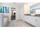 Bright bathroom with tiled floor, double sinks, granite counters, walk-in shower, and a soaking tub at 780 Drop Shot Dr, Davenport, FL 33896
