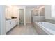 Bright bathroom with a large tub, glass-enclosed shower, and double sink vanity with gray countertops at 780 Drop Shot Dr, Davenport, FL 33896