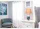 Cozy bedroom corner featuring a plush chair, white curtains, and a stylish bedside table with a lamp at 780 Drop Shot Dr, Davenport, FL 33896