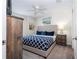 Cozy bedroom with a queen bed, a rustic wood barn door, and neutral decor, creating a relaxing ambiance at 780 Drop Shot Dr, Davenport, FL 33896