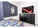 Cool bedroom featuring a dark blue wall with Star Wars decor, and a television on a dresser at 780 Drop Shot Dr, Davenport, FL 33896