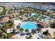Aerial view of resort-style community pool with lounge chairs and palm trees on a sunny day at 780 Drop Shot Dr, Davenport, FL 33896