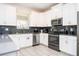 Kitchen with stainless steel appliances, gray counters, and white cabinetry at 780 Drop Shot Dr, Davenport, FL 33896