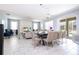 Bright living room with dining area, modern tile floors, and sliding glass door to pool at 780 Drop Shot Dr, Davenport, FL 33896