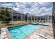 Private swimming pool and spa in a screened enclosure, showcasing the backyard's recreational features at 780 Drop Shot Dr, Davenport, FL 33896