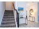 Carpeted staircase with dark wood railing and decorative art in the entryway at 780 Drop Shot Dr, Davenport, FL 33896