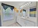 Bathroom with double sinks, white cabinetry, and a large mirror for a clean, functional space at 786 Oxford Dr, Davenport, FL 33897