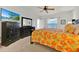 Cozy bedroom with a floral comforter, black dressers, TV, and a ceiling fan at 786 Oxford Dr, Davenport, FL 33897