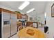 Modern kitchen with stainless steel refrigerator, brown cabinets, and a round wooden table with white chairs at 786 Oxford Dr, Davenport, FL 33897