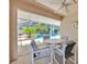 Covered patio with table and chairs, overlooking the screened-in pool and lush greenery at 786 Oxford Dr, Davenport, FL 33897