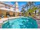 Spacious pool area with a spa, seating, and lush landscaping, enclosed with a screen at 786 Oxford Dr, Davenport, FL 33897