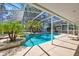 Inviting pool area featuring lush greenery, palm trees, and comfortable patio space at 786 Oxford Dr, Davenport, FL 33897