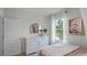A bright bedroom featuring a white dresser with a decorative mirror and a large window at 801 Ambleside Dr, Haines City, FL 33844