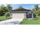 Charming single-story home featuring a two-car garage, well-manicured lawn, and tropical landscaping at 801 Ambleside Dr, Haines City, FL 33844