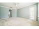 Spacious bedroom with a light blue color scheme, neutral carpet, and glass door to backyard at 807 Ayden Oak Ln, Ocoee, FL 34761