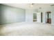 Large bedroom with neutral carpet, light blue walls, and doorway to the bathroom at 807 Ayden Oak Ln, Ocoee, FL 34761
