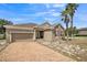 Attractive single-story home boasts a brick driveway, and delightful curb appeal with mature palm trees at 807 Ayden Oak Ln, Ocoee, FL 34761