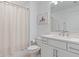 Bright bathroom featuring a double vanity, mirror and a shower with a curtain at 8105 Fenton St, Orlando, FL 32836