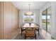 Dining area with stylish table and chairs, modern lighting, wood accent wall, and sliding glass doors to outdoor space at 8105 Fenton St, Orlando, FL 32836