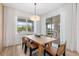 Dining room features a wood table, stylish chairs, modern lighting, and large windows with natural light at 8105 Fenton St, Orlando, FL 32836