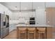 Well-equipped kitchen with an island and barstools features stainless steel appliances and sleek cabinetry at 8105 Fenton St, Orlando, FL 32836
