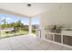 Covered patio featuring an outdoor kitchen with stainless steel appliances and a serene view of the backyard at 8105 Fenton St, Orlando, FL 32836