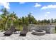 Outdoor patio features a built-in stone bench, inviting fire pit, and comfortable chaise lounge chairs, perfect for relaxation at 8105 Fenton St, Orlando, FL 32836