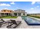 Gorgeous pool and spa area features sleek lounge chairs, a modern patio, and a lush green lawn, creating a serene backyard oasis at 8105 Fenton St, Orlando, FL 32836