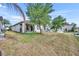 Expansive backyard with healthy lawn and mature trees, partially dry, with a view of neighboring houses at 822 Sheen Cir, Haines City, FL 33844
