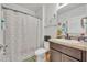 Functional bathroom featuring a toilet, shower with floral curtain, and vanity with ample storage at 822 Sheen Cir, Haines City, FL 33844