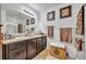 Well-lit bathroom featuring a double sink vanity, framed artwork, and glass-enclosed shower at 822 Sheen Cir, Haines City, FL 33844