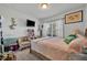Bright bedroom with a window, TV, and seating area; decorated with colorful accents and personal items at 822 Sheen Cir, Haines City, FL 33844