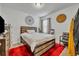 Bedroom featuring a wooden bed frame, red rug, modern decor, and a large wall clock at 822 Sheen Cir, Haines City, FL 33844