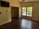 Well-lit bedroom with hardwood floors, a ceiling fan, large window, and an open walk-in closet at 872 Huckleberry Ln, Winter Springs, FL 32708