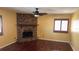 Cozy living room featuring a brick fireplace, wood floors, and natural light from the windows at 872 Huckleberry Ln, Winter Springs, FL 32708