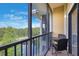 Balcony with table and chairs overlooking private pond with mature trees at 9055 Treasure Trove Ln # 501, Kissimmee, FL 34747
