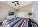 Cozy bedroom features a ceiling fan, television, and closet at 9055 Treasure Trove Ln # 501, Kissimmee, FL 34747