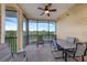 Screened-in patio with ceiling fan, table, chairs and views of lush landscaping at 9055 Treasure Trove Ln # 501, Kissimmee, FL 34747