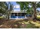 View of the backyard featuring a patio and screened in porch shaded by large trees at 10108 Matchlock Dr, Orlando, FL 32821