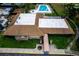 Aerial view of a community clubhouse featuring a pool, tennis court, and lush greenery at 10108 Matchlock Dr, Orlando, FL 32821