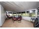Enclosed back porch with dining table and chairs, red lounge chair, and privacy from the sun at 10108 Matchlock Dr, Orlando, FL 32821