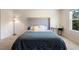 Cozy bedroom featuring a plush bed with a tufted headboard, a desk, and a large window at 1105 Grand Hammock Ct, Kissimmee, FL 34746