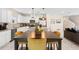 Bright kitchen featuring white cabinets, stainless steel appliances, a granite island, and a dining area with stylish mustard-colored chairs at 1105 Grand Hammock Ct, Kissimmee, FL 34746
