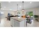 Spacious open plan: island with breakfast bar, dining table with mustard chairs, living room and view of the patio beyond at 1105 Grand Hammock Ct, Kissimmee, FL 34746
