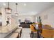 Open concept view of the kitchen island, breakfast bar, dining table and the living room beyond featuring a big screen tv at 1105 Grand Hammock Ct, Kissimmee, FL 34746
