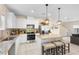 Bright kitchen featuring white cabinets, stainless steel appliances, a granite island, with bar stool seating, for cooking and entertaining at 1105 Grand Hammock Ct, Kissimmee, FL 34746