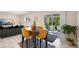 Cozy dining area with mustard-colored chairs adjacent to a living room with access to an outdoor patio, creating a welcoming ambiance at 1105 Grand Hammock Ct, Kissimmee, FL 34746